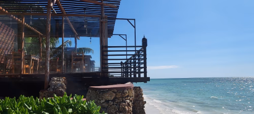 Strand med uteservering och hav